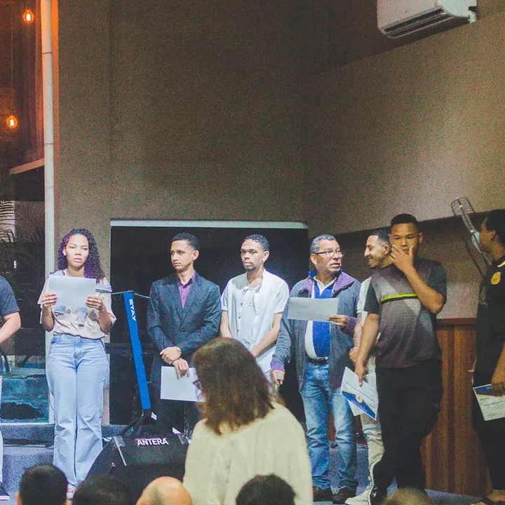 Formandos no palco com o certificado de conclusão